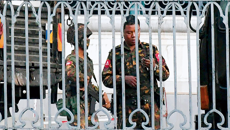 緬甸軍方在仰光市政廳看守。政變為緬甸因疫情受挫的經濟狀況再雪上加霜。